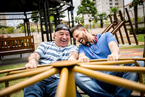Two men spinning on a playground roundabout