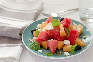 mixed melon chunks with feta cheese served on a plate